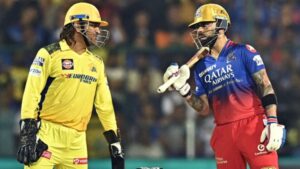 Virat Kohli and MS Dhoni smiling and greeting each other during an IPL match, representing RCB and CSK.